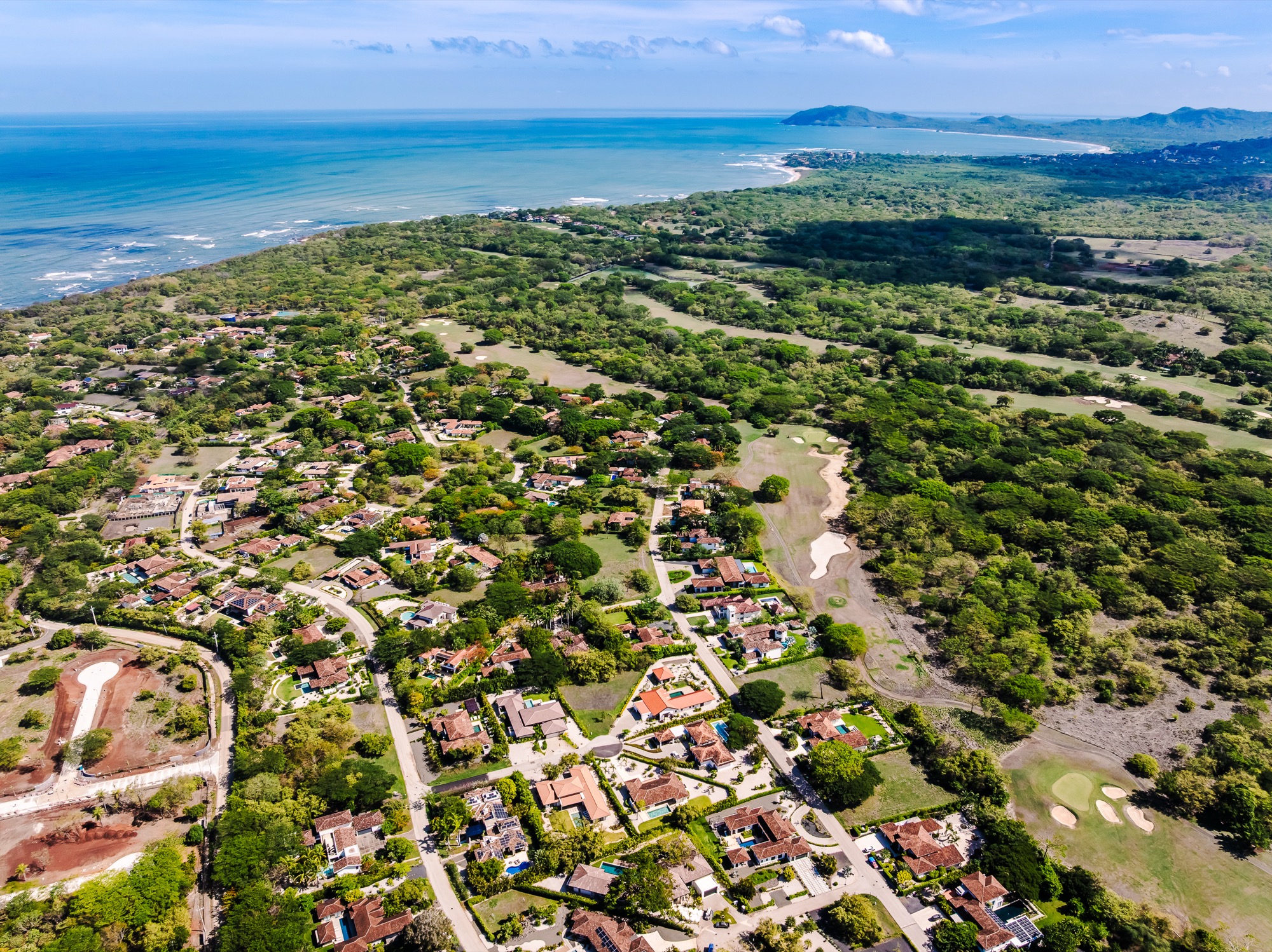 Hacienda Pinilla from the air: forest, fairways and houses running down to the Pacific