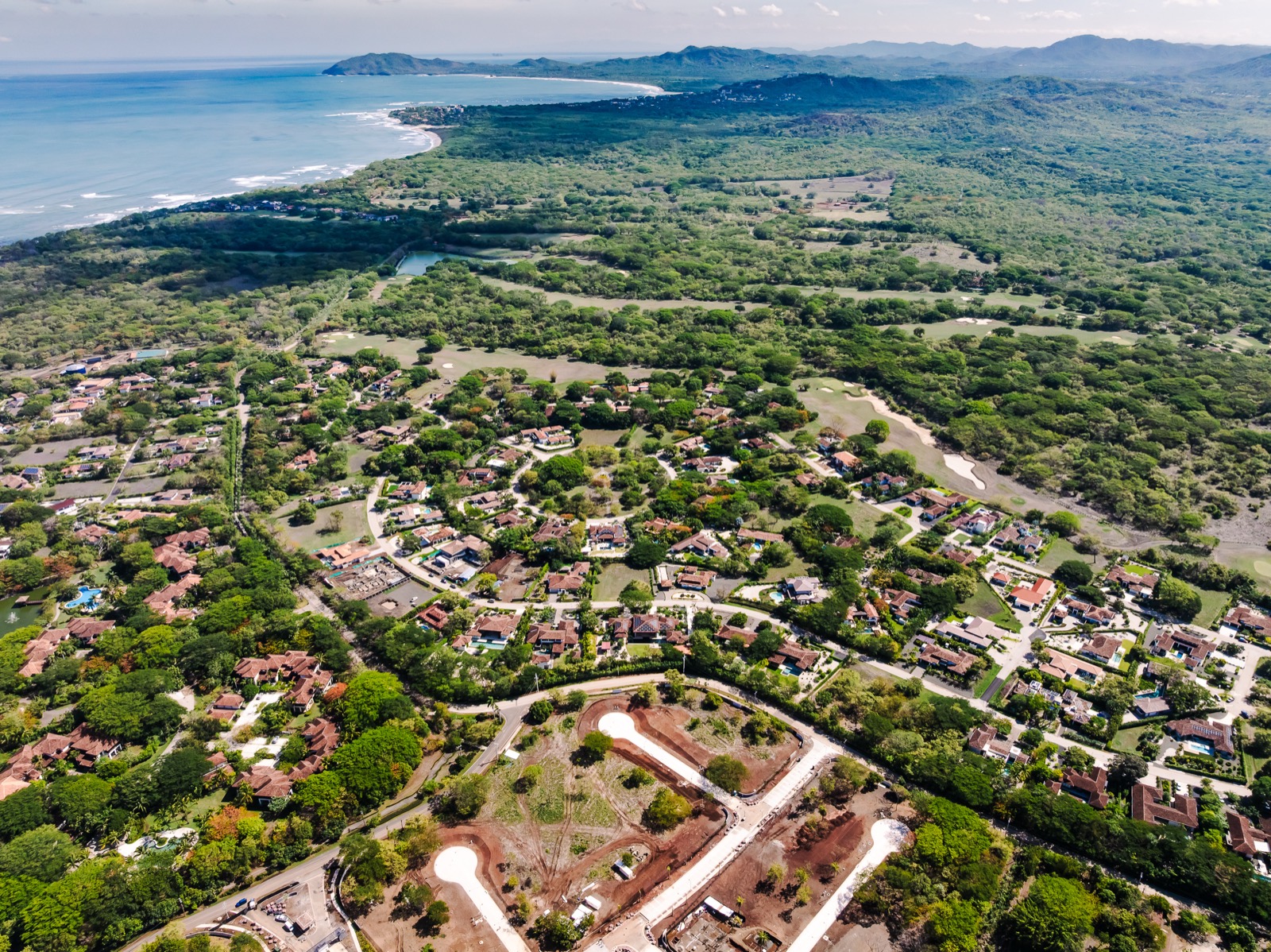 Hacienda Pinilla from the air: homes, golf fairways and forest by the Pacific